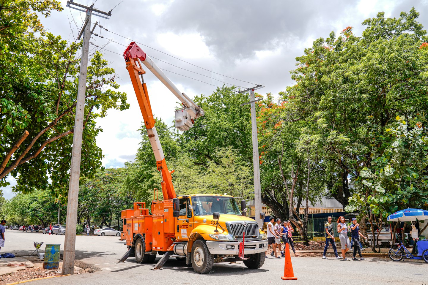 Bucket truck working on utility pole with extended boom.